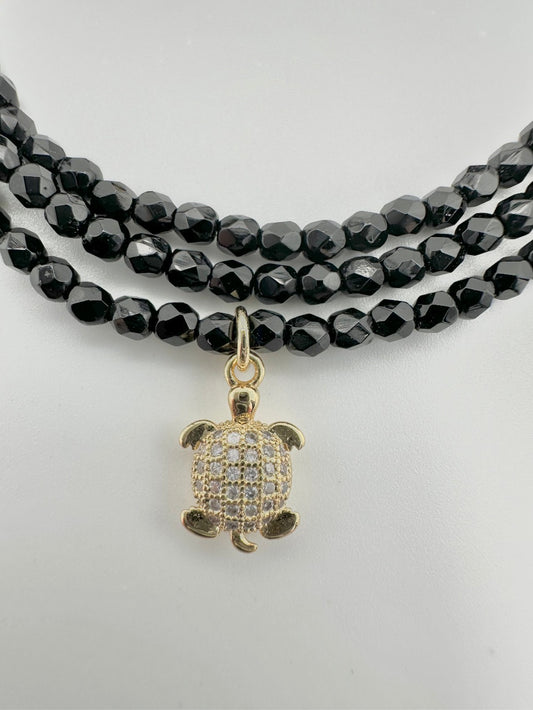 Les Cajoux 2 en 1 bracelet ou collier en façade de bohème noir, vous y retrouverez sa petite tortue dorée en breloque