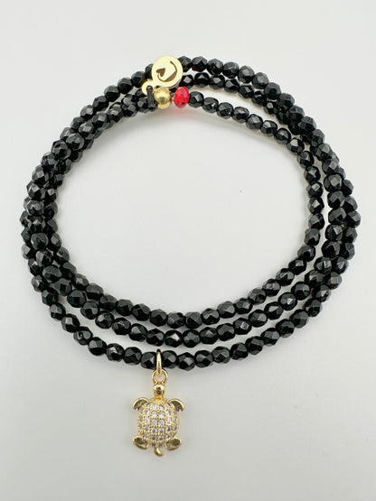 Les Cajoux 2 en 1 bracelet ou collier en façade de bohème noir, vous y retrouverez sa petite tortue dorée en breloque