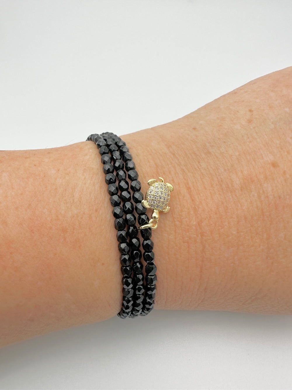 Les Cajoux 2 en 1 bracelet ou collier en façade de bohème noir, vous y retrouverez sa petite tortue dorée en breloque