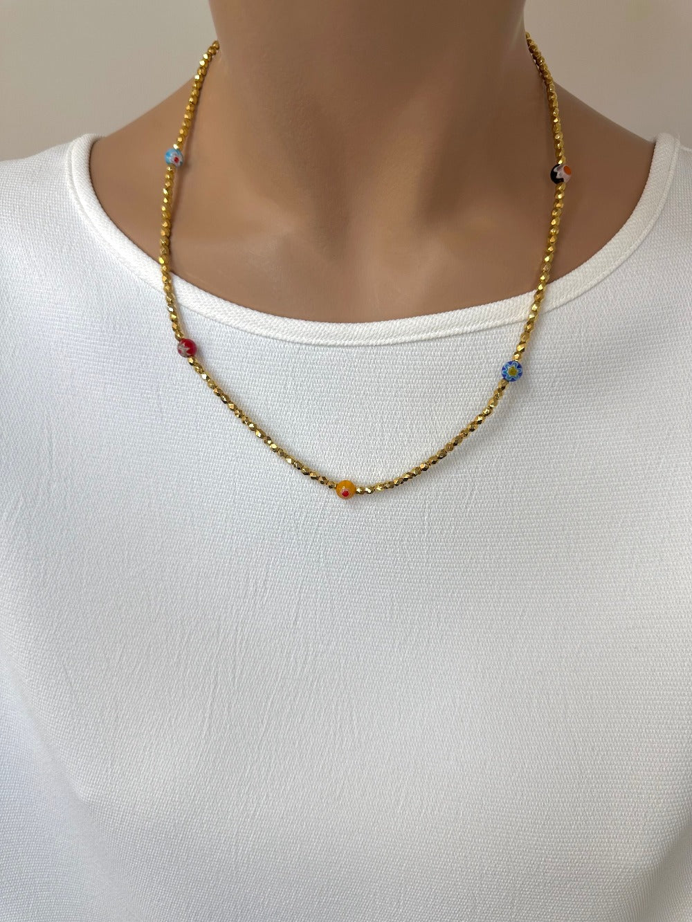 Ce bijou est composé de facettes de Bohème couleur Or plaqué 24K sur un fil élastique de grande qualité. On y retrouve aussi des perles rondes Millefiori.
